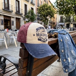 Casquette Madrid bicolore à façade crème et visière délavée, sur une terrasse à Madrid