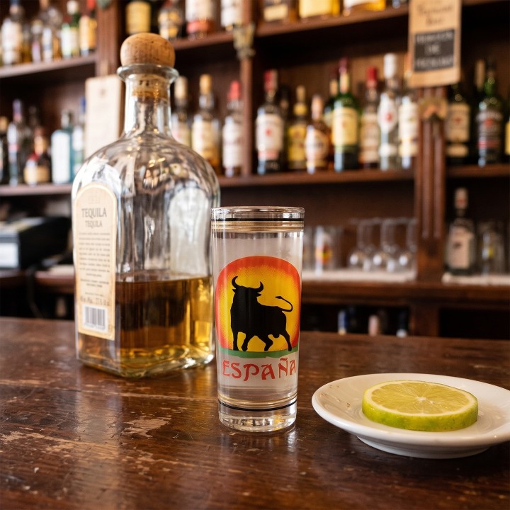 Verre à tequila de Madrid, modèle Taureau, sur un comptoir avec tequila et citron vert
