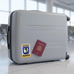 Madrid sticker on a suitcase next to a passport