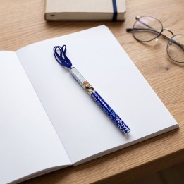 Bolígrafo oficial del Real Madrid con cordón sobre un cuaderno abierto