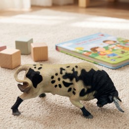 Taureau jouet qui charge sur un tapis d’enfant avec des cubes en bois