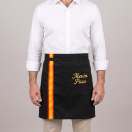 Black waist apron with the Spanish flag and the name «Mesón Paco» embroidered in gold