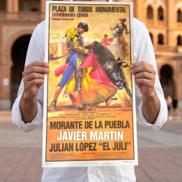 Man holding a personalised bullfight poster in front of the bullring