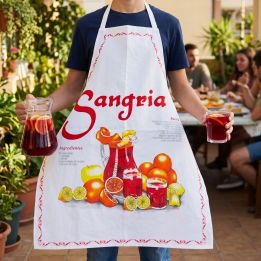 Jeune homme portant le tablier Sangria servant une carafe de sangria sur une terrasse entre amis
